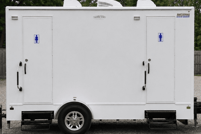 White portable restroom trailer with separate men's and women's doors, featuring steps and handles.